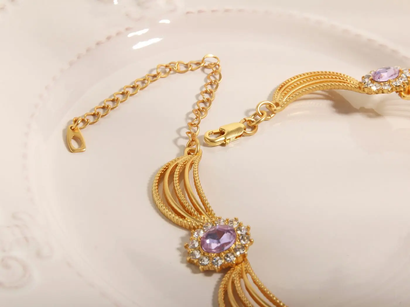 A gold necklace with a violet centre stone, of the kind kept at the counter